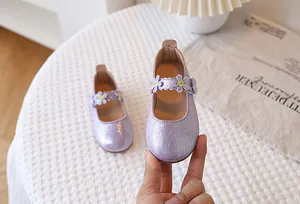 Macro view of purple girls Mary Jane shoes featuring sequin texture and daisy lace flower