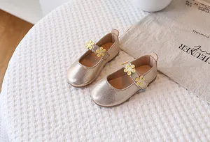 Detail of champagne gold girls' Mary Jane shoes with delicate sunflower decorations