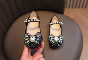 Dettaglio scarpe Mary Jane nere glitterate per bambina con fiocco e cinturino di perle