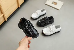 Detail of children's patent leather loafers with crocodile texture and velcro strap