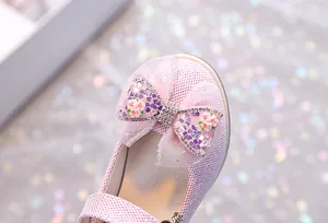 Détail de chaussure de princesse rose pour fille avec nœud en tulle et strass brillants