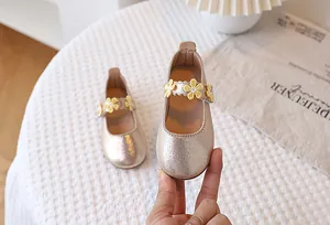 Detail of champagne gold girls mary jane shoes with delicate yellow floral accents