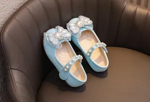 Dettaglio macro della scarpa da principessa blu glitter con fiocco e perle