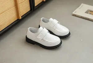 Detail of white crocodile-embossed leather boys' shoes with black thick lug sole