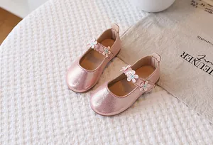 Detail of pink glitter Mary Jane shoes with three white floral appliques and heel pull tab