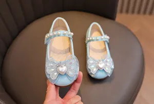 Dettaglio di una scarpa da principessa glitterata blu chiaro con cinturino di perle