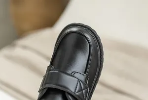 Close-up of boys black matte leather dress shoes with velcro strap and cross stitching