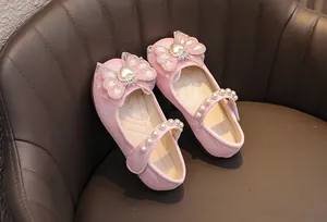 Dettaglio di scarpe da principessa rosa glitterate con fiocco in tulle e perline