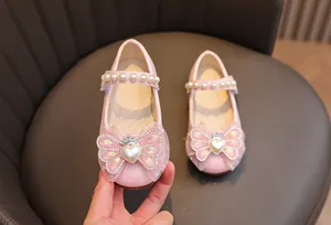 Dettaglio scarpe da principessa rosa glitterate con fiocco, perle e fibbia a corona
