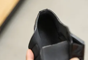 Close-up of boys black dress shoes showing breathable mesh lining and neat stitching