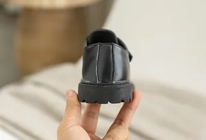 Detail view of the thick non-slip sole and precise stitching on black leather boys shoes