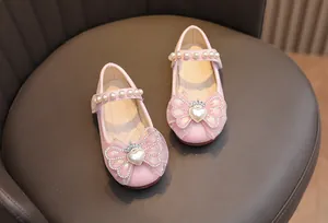 Dettaglio di scarpe Mary Jane rosa glitterate con fiocco in tulle e corona di perle