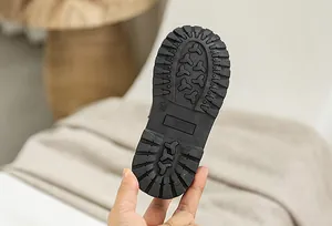 Detail of black non-slip rubber sole with deep tread and size 26 marking for boys shoes