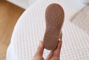 Close-up of non-slip rubber sole for girls' shoes featuring size 23 and shield logo