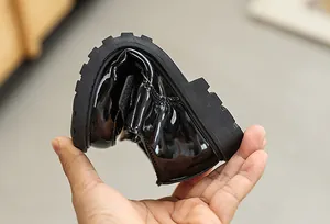 Detail showing high flexibility and flexible rubber sole of black patent boys' dress shoes