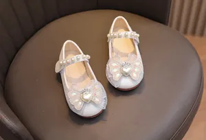 Dettaglio di scarpe da principessa con paillettes argento e fiocco di organza