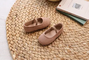 Close-up of pink Mary Jane children shoes with matte texture on a natural straw mat