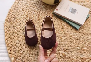Close-up of velvet texture and elastic strap on burgundy girls Mary Jane shoes