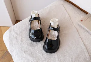 Detail of girls black patent leather Mary Jane shoes with hook and loop closure