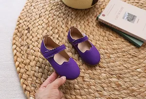 Detail von lila Mädchen-Mary-Janes mit gewelltem Rand und Klettverschluss-Riemen