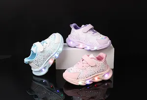 Detail of light-up kids sneakers in pastel colors with LED soles and velcro straps