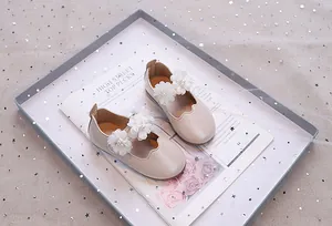 Detail von Mädchen Mary Janes mit feinen Organza-Blüten und eleganten Perlenverzierungen