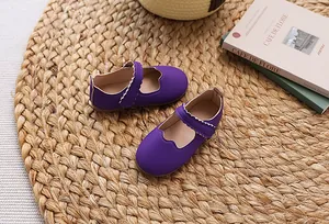 Detailansicht lila Mädchen Mary Jane Schuhe mit Wellenrand und Klettverschluss auf Matte