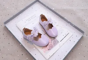 Detail von hellvioletten Mary Jane Schuhen mit Stoffblume und Perlenverzierung