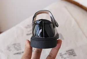 Close-up of black patent leather Mary Jane shoes featuring a thick non-slip rubber sole