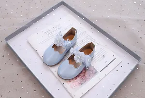 Detail von hellblauen Glitzer-Mary-Jane-Schuhen mit Netzblumen und Perlenakzenten