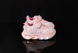 Detail of pink girls' sneaker with glowing colorful LED lights on the thick sole