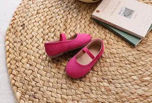 Detail of girls' fuchsia suede Mary Jane flats with elastic strap and round toe design