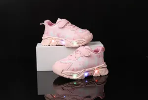 Detail of pink girls sneakers with glowing LED lights and butterfly print on the side
