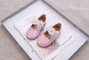 Details von rosa Glitzer-Mary-Janes mit Netzblumen und weißen Kunstperlen