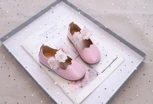 Detailansicht der glitzernden Mädchen-Prinzessin-Schuhe mit Tüllblumen und Perlen in Rosa