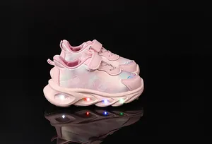 Detail view of pink girl's LED light-up sneakers with heart prints and glowing soles