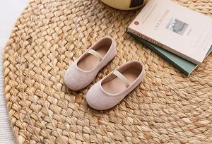 Detailed top view of pink Mary Jane flat shoes on straw mat for young girls