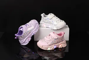 Détail de la semelle LED lumineuse et du motif papillon iridescent sur chaussures enfant