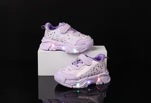 Détail de baskets violettes pour tout-petits avec lumières LED et nœud holographique