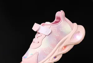 Detailed close-up of pink girls' sneakers with vibrant LED lights and heart patterns