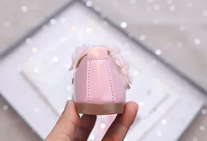 Detailansicht der rosa Mädchen-Prinzessinenschuhe mit Perlmuttglanz und Blumendetail