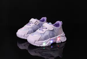 Dettaglio di sneakers viola da bambina con suola a LED luminosa e cinturino velcro