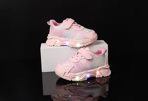 Dettaglio di scarpe da ginnastica rosa sfumato per bambina con velcro e suola a LED