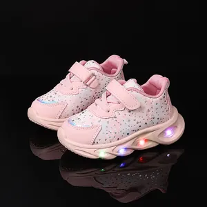 Pink girl's sneakers with floral patterns and LED light-up soles on black background