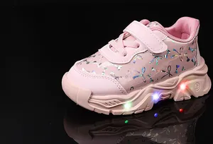 Détail de baskets roses pour enfants avec semelle lumineuse LED et motifs laser