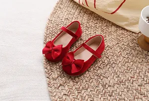 Detail van rode fluwelen Mary Jane ballerina's voor meisjes met een strik