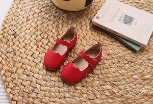 Nahaufnahme roter Mary Jane Ballerinas für Mädchen mit Wellenrand und mattem Finish