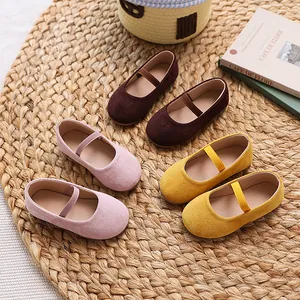 Cute candy-colored girls' Mary Jane flats with elastic straps on a woven mat