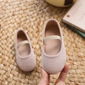 Pink Mary Jane flat shoes for girls with elastic strap shown on a soft textured background