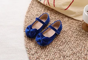 Detail van donkerblauwe fluwelen meisjes Mary Jane schoenen met grote strik en klittenband